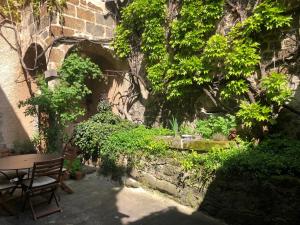 a patio with a table and chairs and trees at La Demeure du Lac de Fugeres in Le Puy en Velay