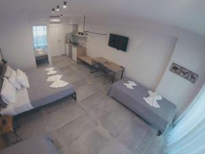 a room with two beds and a table and a television at Alesta Apartments in Stavros