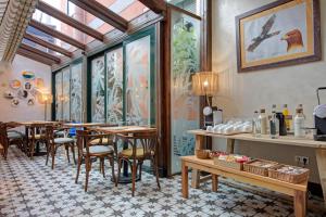 a restaurant with tables and chairs in a room at Hospedium Hotel La Farm in La Granja de San Ildefonso