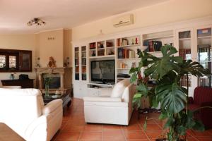 a living room with white furniture and a plant at Villa Delle Palme Delfina in Trapani