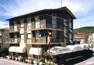 a woman standing on the balcony of a building at Hotel Chenno in Subbiano
