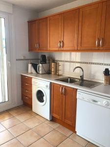una cucina con lavatrice e lavandino di Appartement vinaros proche de la mer a Sant Jordi