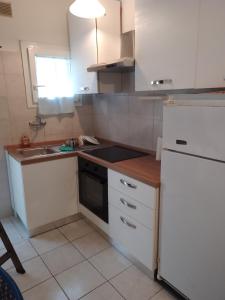 a kitchen with white cabinets and a sink and a stove at condominio guanabara in Lido di Jesolo