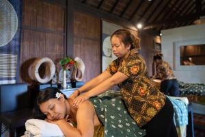 a woman is giving a woman a massage at Awan Putih Resort Ubud in Payangan
