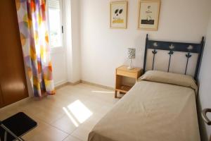 a bedroom with a bed and a window at Atico Piles in Piles