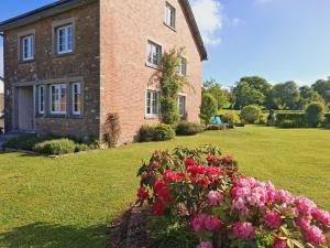 a brick house with flowers in front of it at La Renée'Sens in Houffalize