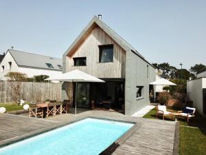 una casa con piscina delante de una casa en Kerguille, villa avec piscine, en La Trinité-sur-Mer