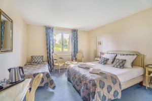 Postel nebo postele na pokoji v ubytování Hôtel Le Clos des Arts