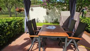 a wooden table with four chairs and an umbrella at Ferienwohnung Zur Ziegelei in Groß Kreutz