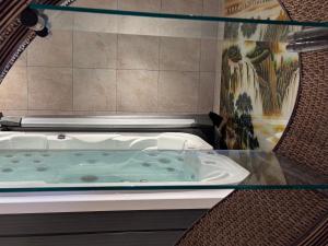 a jacuzzi tub in a room with a painting at Chambres côté mer du bouquet in Cosqueville +52 photos