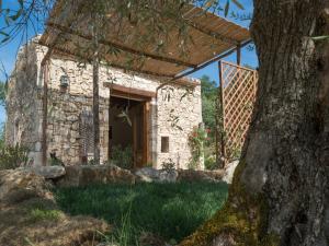 ein Steingebäude mit einem Baum davor in der Unterkunft Agriturismo Fontenuova in Saturnia