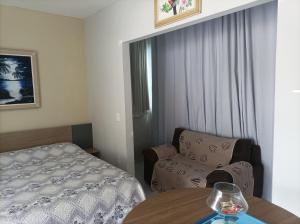 a bedroom with a bed and a chair and a table at Flat Vista do Cruzeiro in Jacobina +18 photos