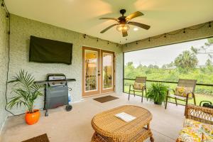 a screened in porch with a television and a grill at Sunny Stays Vacation Rental in Southwest Florida! in Lehigh Acres