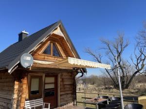 a small log cabin with awning and a grill at Domki z bali Polanica-Zdrój in Polanica-Zdrój