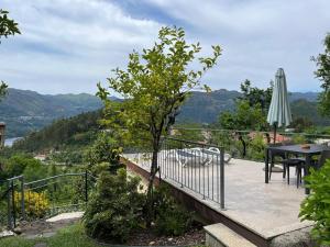 a balcony with a table and an umbrella at Casa de Casarelhos - Andar da Moradia com terraço - Vistas rio - "Gerês" in Geres +96 photos