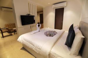 - une chambre dotée d'un lit blanc avec un animal rembourré dans l'établissement Mumbai House Express, à Udaipur