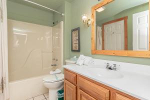 a bathroom with a sink and a toilet and a mirror at 2BR Village At Indian Point 803 near SDC-Free Tickets Daily (up to $500 Value) in Branson +11 photos