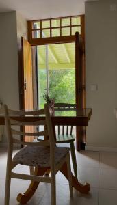 a wooden table and a chair with a table and a window at Casa da Ribeira do Círio in Seia