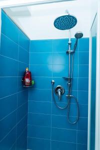 een blauwe betegelde douche met een douchekop bij Alba apartment in Taormina +33 foto's