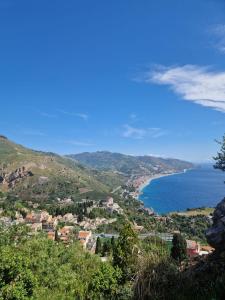 uitzicht op een stad en de oceaan op een heuvel bij Alba apartment in Taormina