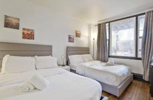 西纽约3BR Skyline Apt in Bustling District I Great Value NJ5的有两张床和一扇窗户的卧室