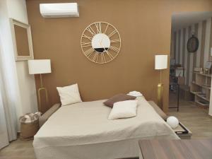 Un dormitorio con una cama grande con un reloj en la pared. en Le Rondini in giardino, en Roma