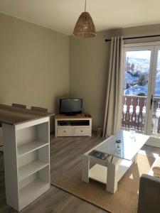 a living room with a tv and a table at La catane in Andon