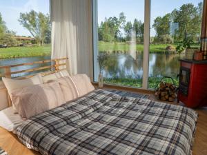 JõgevesteTiny house at countryside的一间卧室，里面有一张床和一扇大窗户。