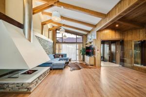 a living room with a blue couch and wooden ceilings at Pirin Golf Lux Villa for Ski & Chill in Bansko