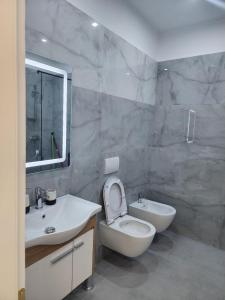 un baño con inodoro y lavabo en N Luxury Apartment, en Vlorë