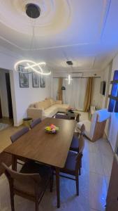 a living room with a dining table and a couch at Elie home in Douala +4 photos
