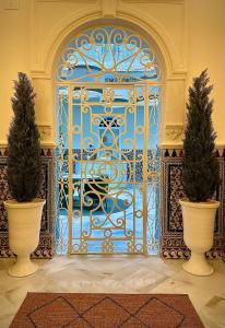 a blue gate with two trees in front of it at Puerta de la Ribera Centro in Córdoba +41 photos