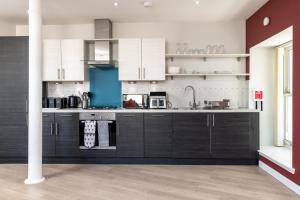a kitchen with white cabinets and a sink at Central comfort and explore nearby cafes in Aberdeen +10 photos