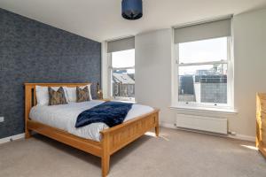 a bedroom with a bed and two windows at Central comfort and explore nearby cafes in Aberdeen