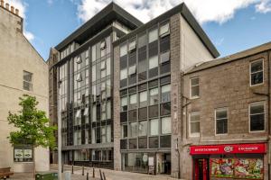 an old brick building with a black roof at Central comfort and explore nearby cafes in Aberdeen