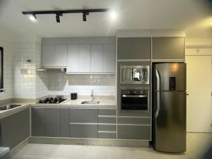 a kitchen with a stainless steel refrigerator and a sink at Ape Completo em Osasco - 15 min de Pinheiros in Osasco