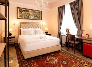 a bedroom with a bed and a desk and a window at Hotel Boutique Patio Andaluz Cali Granada in Cali
