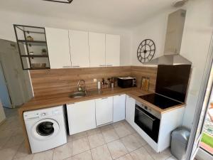 a kitchen with a sink and a washing machine at Charmant 2 pièces, terrasse 30m2 in Antibes