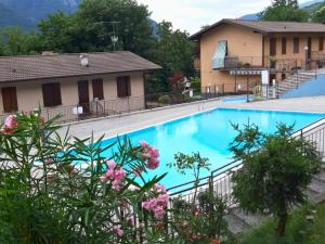 a large blue swimming pool next to a building at Lakefront Apartment with Panoramic Pool in Ranzanico