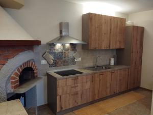 a kitchen with wooden cabinets and a brick oven at Casetta Nel Borgo in Sestri Levante