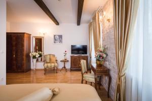1 dormitorio con 1 cama y TV en una habitación en Priska Heritage Rooms, en Split