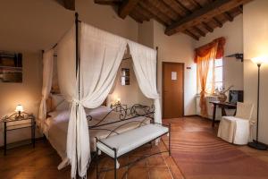 1 dormitorio con cama con dosel en una habitación en Il Conte Matto en Trequanda