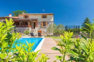 a villa with a swimming pool and a house at Villa Dora - family house with saltwater pool in Gostinjac, Krk Island in Gostinjac