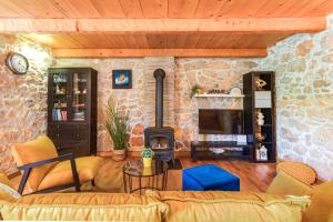 a living room with a couch and a fireplace at Villa Dora - family house with saltwater pool in Gostinjac, Krk Island in Gostinjac