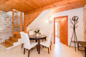 a dining room with a table and white chairs at Villa Dora - family house with saltwater pool in Gostinjac, Krk Island in Gostinjac