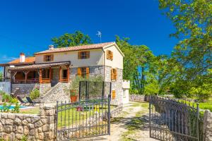 a stone house with a gate in front of it at Villa Dora - family house with saltwater pool in Gostinjac, Krk Island in Gostinjac