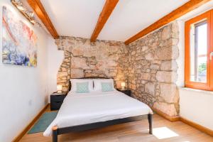 a bedroom with a stone wall and a bed at Villa Dora - family house with saltwater pool in Gostinjac, Krk Island in Gostinjac +36 photos