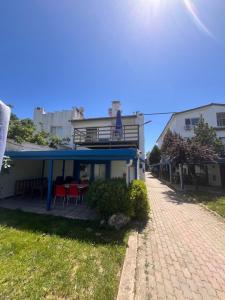 a house with a blue roof and chairs on a patio at Ennis İnn Resort Hotel in Marmaraereglisi
