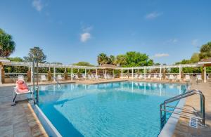 a large swimming pool with a red chair in a resort at 2 Mi to Lake Sumter Landing Spacious Golf Retreat in The Villages