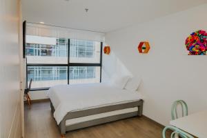 ein weißes Schlafzimmer mit einem Bett und einem Fenster in der Unterkunft Estudio en Usaquén cerca a la Fundación Santa Fe ! in Bogotá